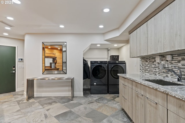 clothes washing area featuring visible vents, baseboards, laundry area, separate washer and dryer, and a sink