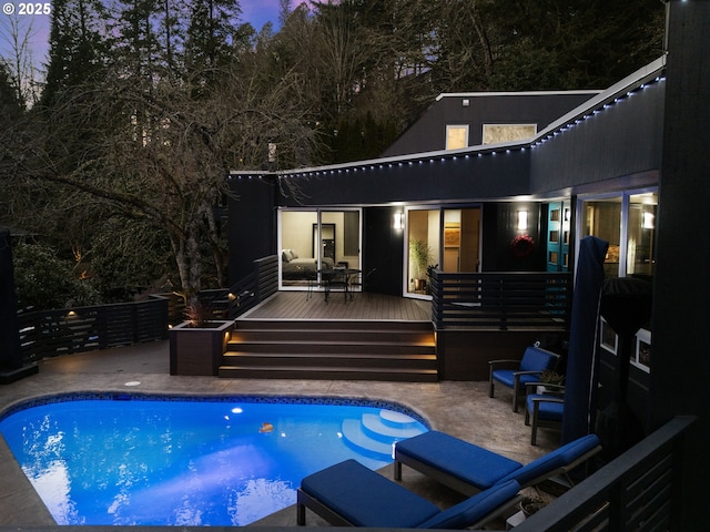 rear view of house with a patio area, a fenced in pool, and a wooden deck