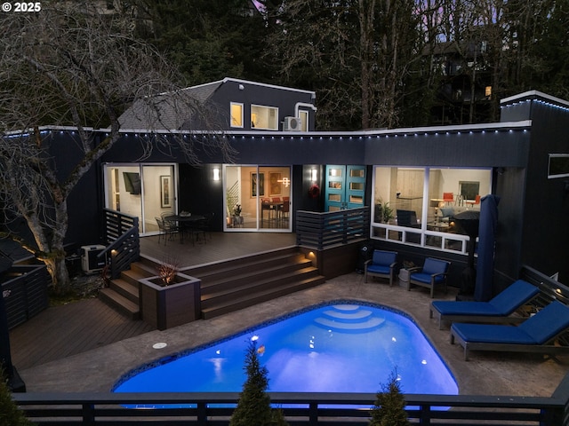 rear view of house featuring an outdoor pool, a patio, a deck, and outdoor dining space