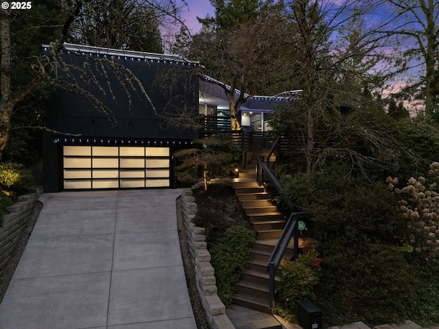view of front of house featuring stairway, concrete driveway, and a garage