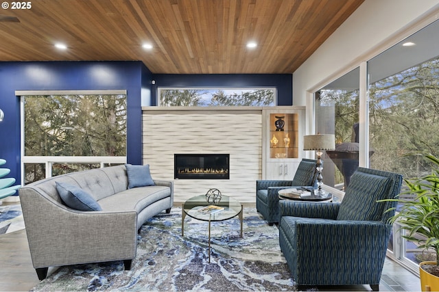 living area with a glass covered fireplace, wooden ceiling, wood finished floors, and recessed lighting