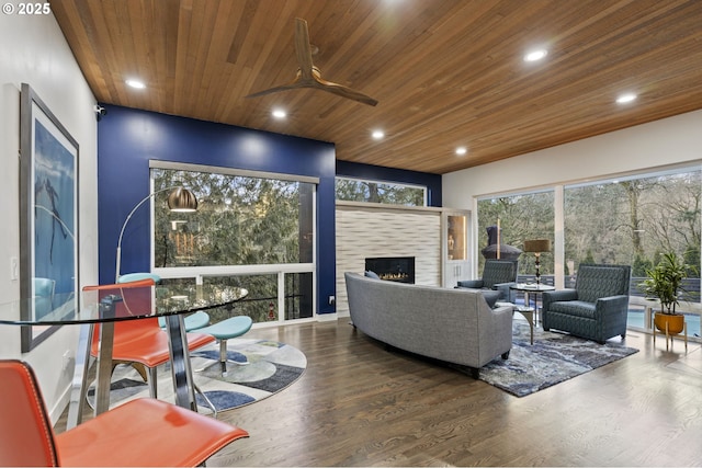 living room featuring a ceiling fan, wood finished floors, recessed lighting, a tile fireplace, and wooden ceiling