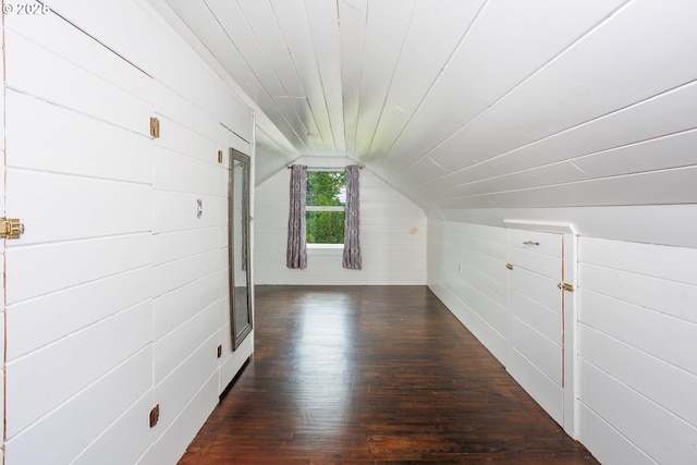 bonus room with vaulted ceiling, dark wood-style flooring, and wooden walls
