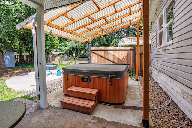 view of patio / terrace with a hot tub and a fenced backyard