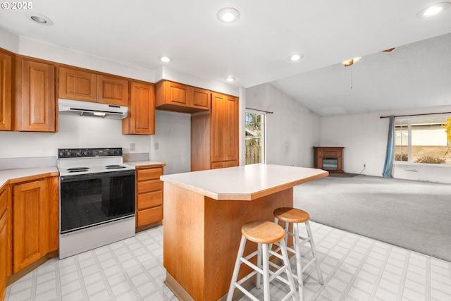 kitchen featuring vaulted ceiling, a kitchen island, a breakfast bar area, light colored carpet, and white range with electric cooktop