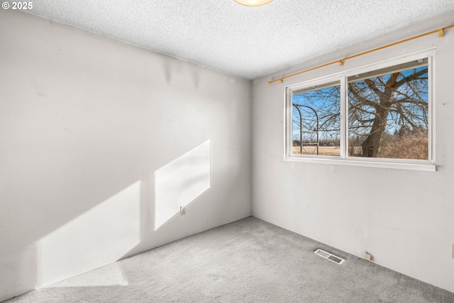 carpeted empty room featuring a textured ceiling