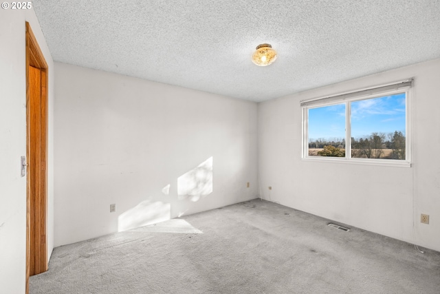 carpeted spare room with a textured ceiling