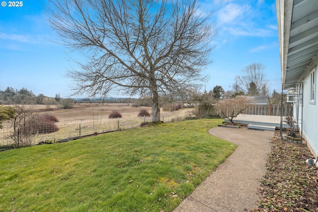 view of yard with a wooden deck and a rural view