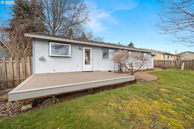 back of house with a wooden deck and a lawn