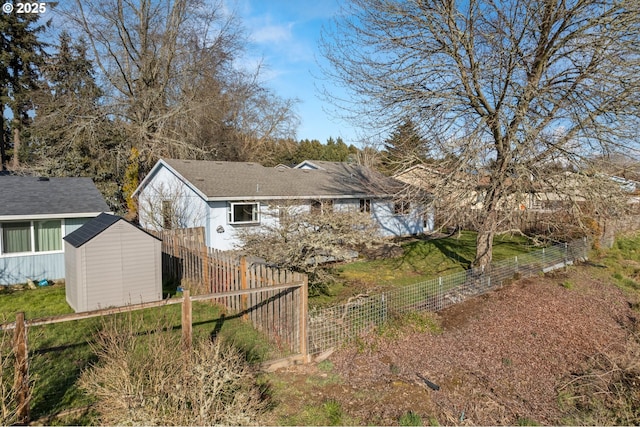 rear view of property with a storage shed