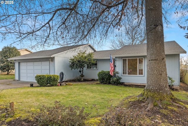 ranch-style house featuring a garage and a front lawn