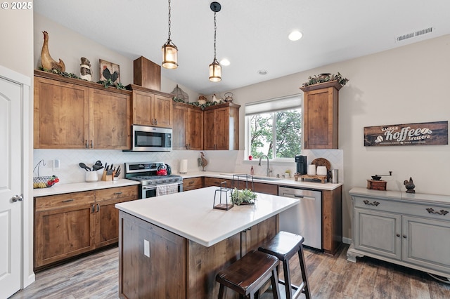 962 S 66th Pl, Springfield, OR 97478 - kitchen featuring appliances with stainless steel finishes, backsplash, a breakfast bar area, light countertops, and light wood finished floors