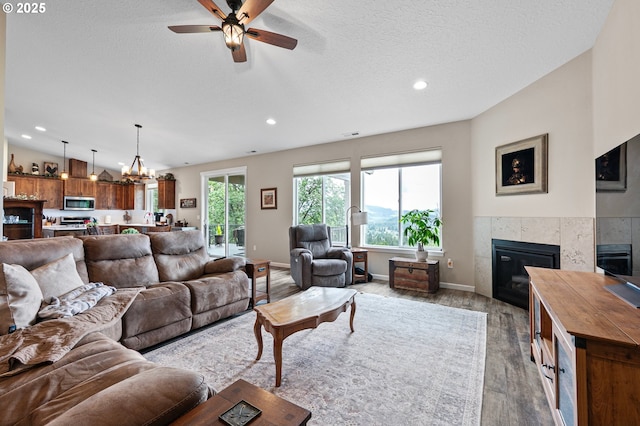 962 S 66th Pl, Springfield, OR 97478 - living room featuring a fireplace, light wood-style flooring, ceiling fan, recessed lighting, and a textured ceiling