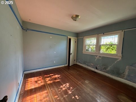 unfurnished bedroom with dark wood-type flooring