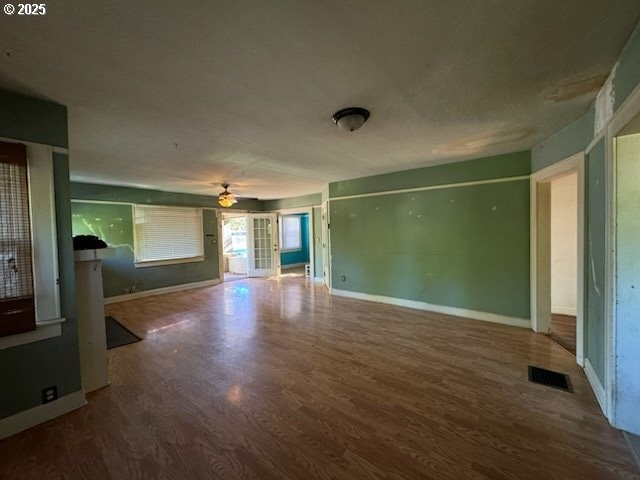 unfurnished living room featuring wood-type flooring and french doors