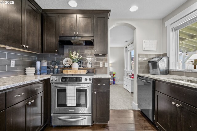 1366 Cramner St, Lafayette, OR 97127 - kitchen with appliances with stainless steel finishes, under cabinet range hood, arched walkways, dark brown cabinets, and dark wood-style flooring