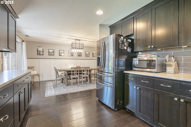 1366 Cramner St, Lafayette, OR 97127 - kitchen featuring appliances with stainless steel finishes, dark wood-style floors, light stone countertops, wainscoting, and decorative backsplash