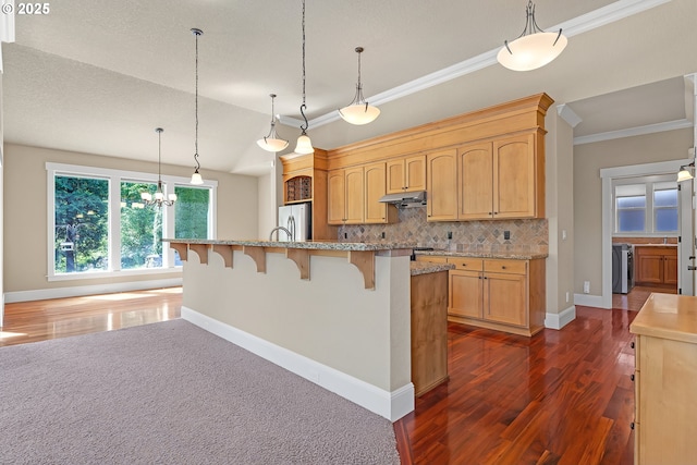 kitchen with dark wood-type flooring, decorative backsplash, a kitchen breakfast bar, crown molding, and baseboards