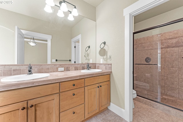 bathroom with a shower stall, toilet, tile patterned floors, and double vanity
