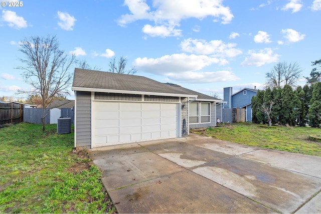 view of front facade with a garage, central air condition unit, and a front yard