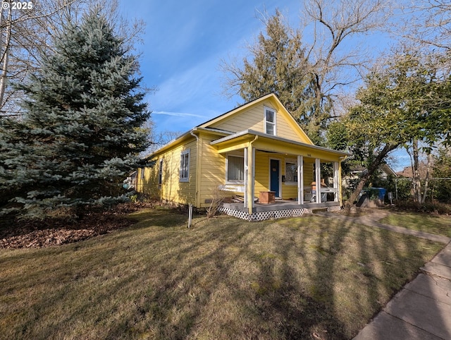 view of front of home with a porch, a front yard, and fence