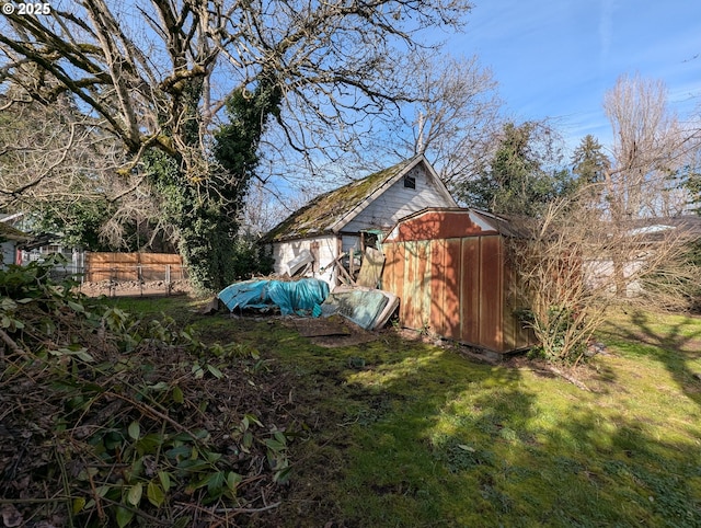 view of yard with an outbuilding, a storage shed, and fence