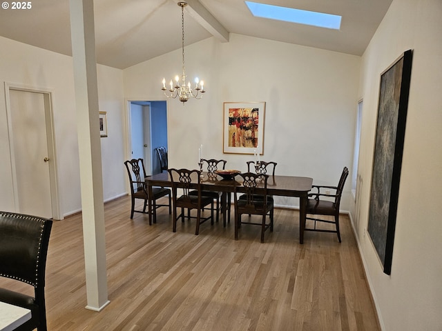 dining room featuring vaulted ceiling with skylight, hardwood / wood-style floors, and a chandelier