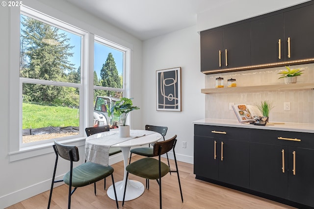 dining space featuring baseboards, an inviting chandelier, and light wood-style flooring