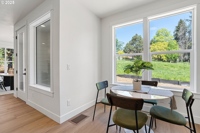 dining space featuring baseboards, light wood finished floors, and visible vents