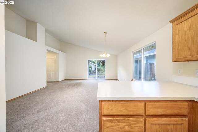 1301 E Sunset Dr, Newberg, OR 97132 - kitchen with lofted ceiling, a peninsula, light colored carpet, light countertops, and a chandelier