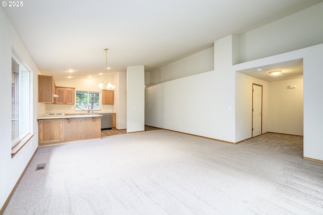 1301 E Sunset Dr, Newberg, OR 97132 - unfurnished living room with a chandelier, vaulted ceiling, light colored carpet, baseboards, and a sink