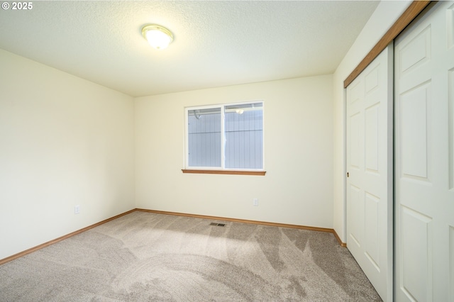 1301 E Sunset Dr, Newberg, OR 97132 - unfurnished bedroom with carpet floors, a closet, baseboards, and a textured ceiling