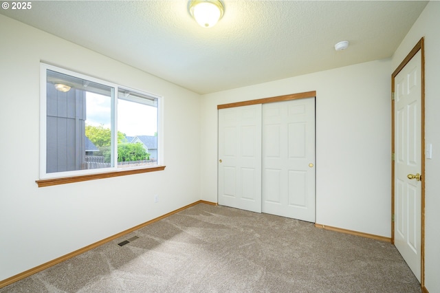 1301 E Sunset Dr, Newberg, OR 97132 - unfurnished bedroom featuring carpet flooring, a closet, baseboards, and a textured ceiling