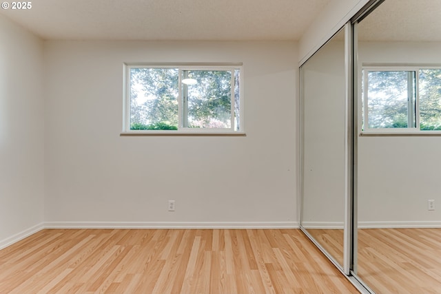331 Limerick Ave, Eugene, OR 97404 - unfurnished bedroom with light wood finished floors, multiple windows, and a closet