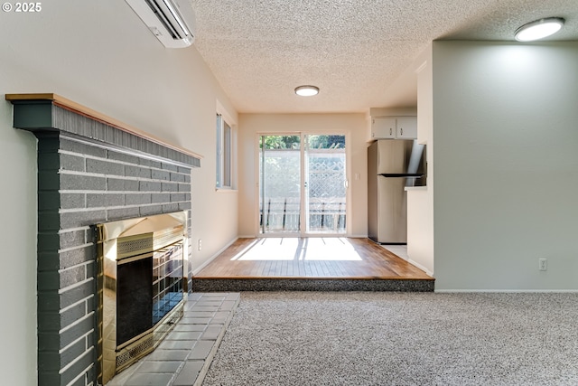 331 Limerick Ave, Eugene, OR 97404 - unfurnished living room with a wall mounted AC, a textured ceiling, a fireplace, and carpet floors