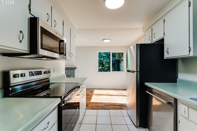 331 Limerick Ave, Eugene, OR 97404 - kitchen featuring stainless steel appliances, light countertops, light tile patterned floors, a textured ceiling, and white cabinetry