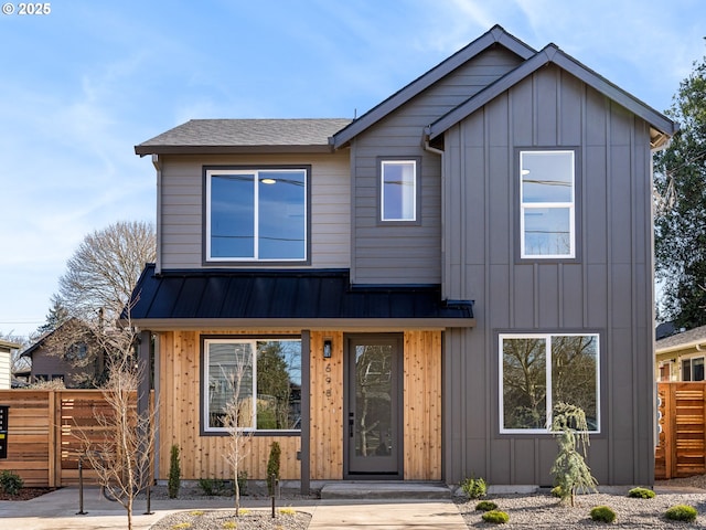 view of front of house featuring a standing seam roof, a shingled roof, board and batten siding, and fence