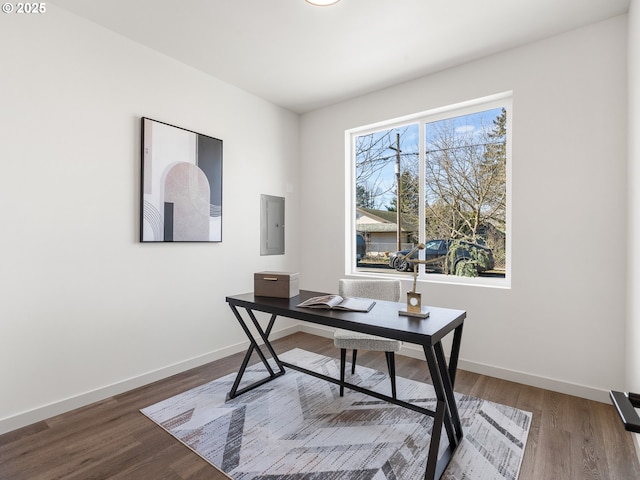 office area with electric panel, baseboards, and wood finished floors