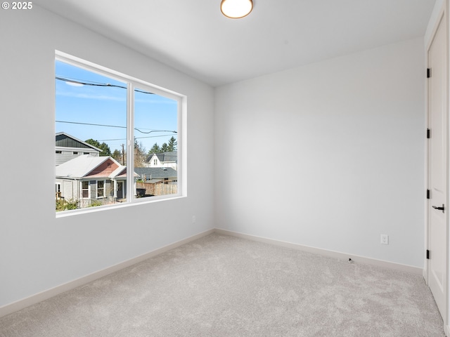 carpeted spare room with baseboards