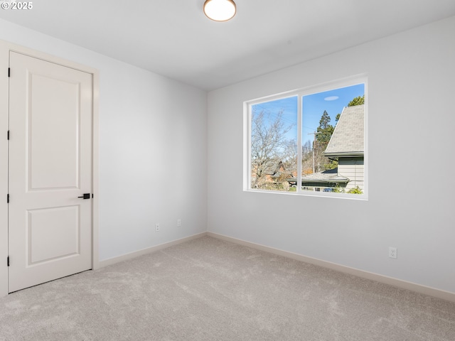 carpeted empty room with baseboards