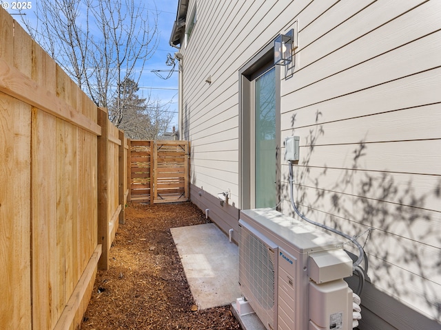 view of side of home with ac unit and a fenced backyard