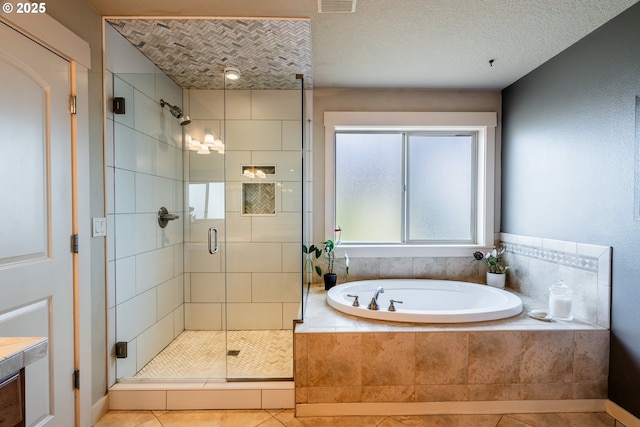 bathroom with tile patterned flooring, independent shower and bath, and a textured ceiling