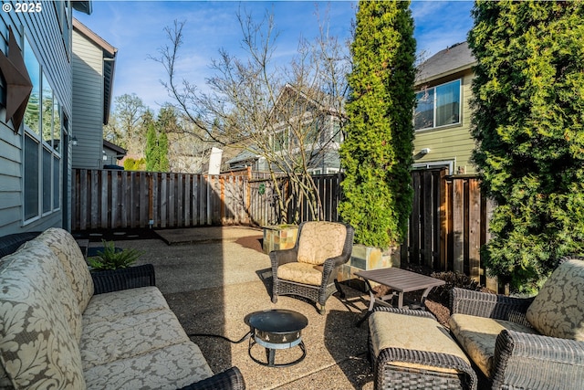 view of patio with an outdoor living space with a fire pit