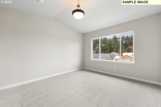 carpeted empty room with lofted ceiling and baseboards