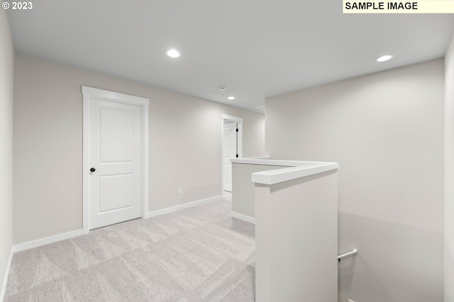 interior space with baseboards, recessed lighting, an upstairs landing, and light colored carpet