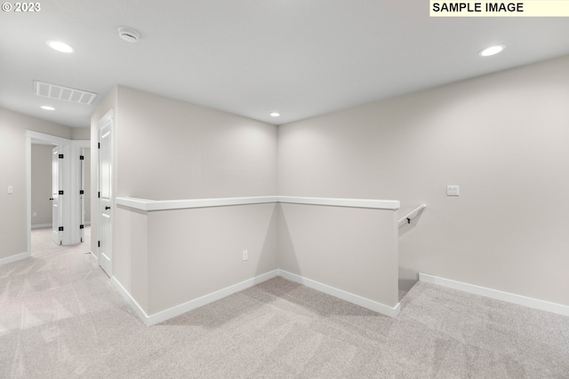 hallway with recessed lighting, baseboards, visible vents, and an upstairs landing