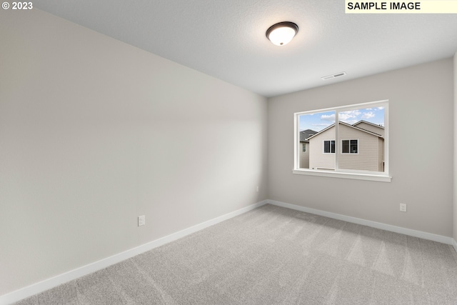 empty room with baseboards, visible vents, and carpet flooring