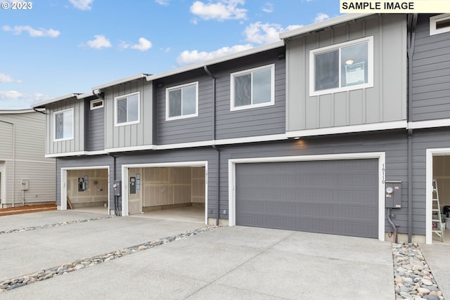 multi unit property featuring a garage, board and batten siding, and concrete driveway