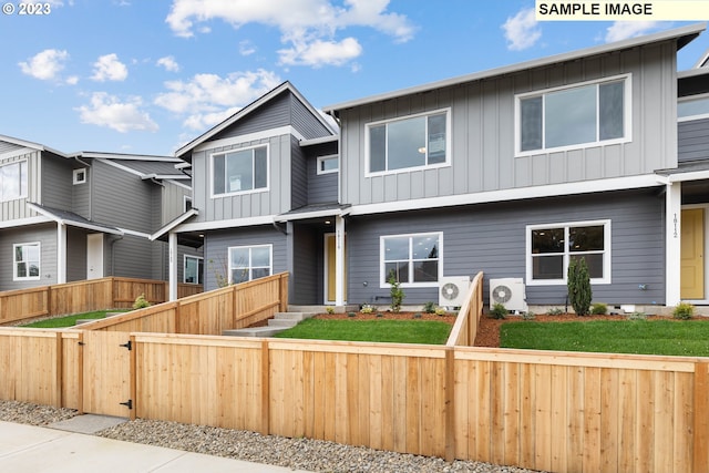 view of front facade featuring board and batten siding, a gate, and a fenced front yard