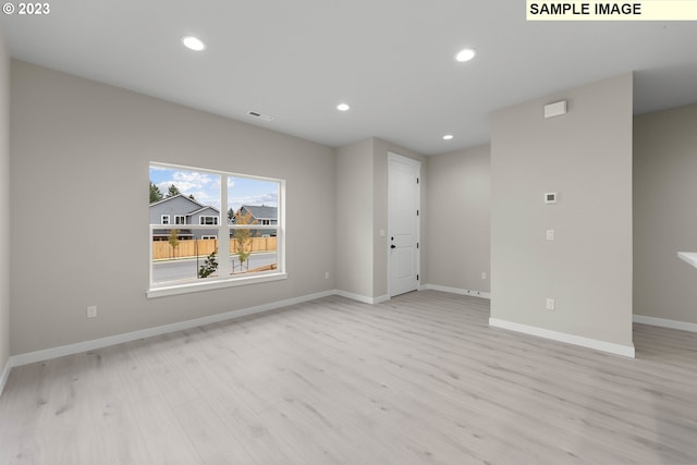 spare room with baseboards, light wood finished floors, visible vents, and recessed lighting